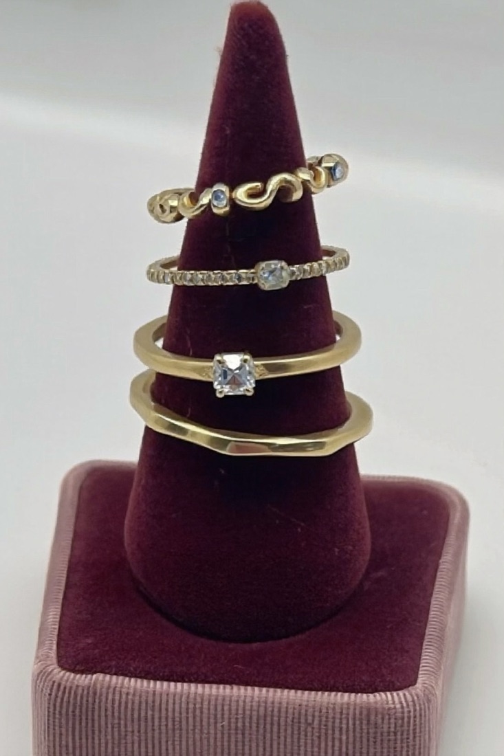Four thin crystal rings on a velvet holder